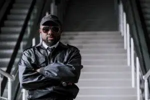 “Security officer standing on stairway with arms crossed, providing a professional and confident presence.”