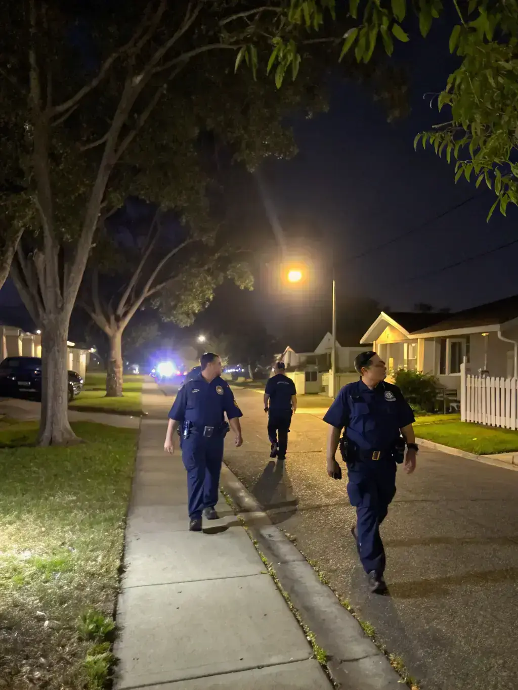 A security guard patrolling a residential street in Glendale at night, ensuring the safety of homes and families.
